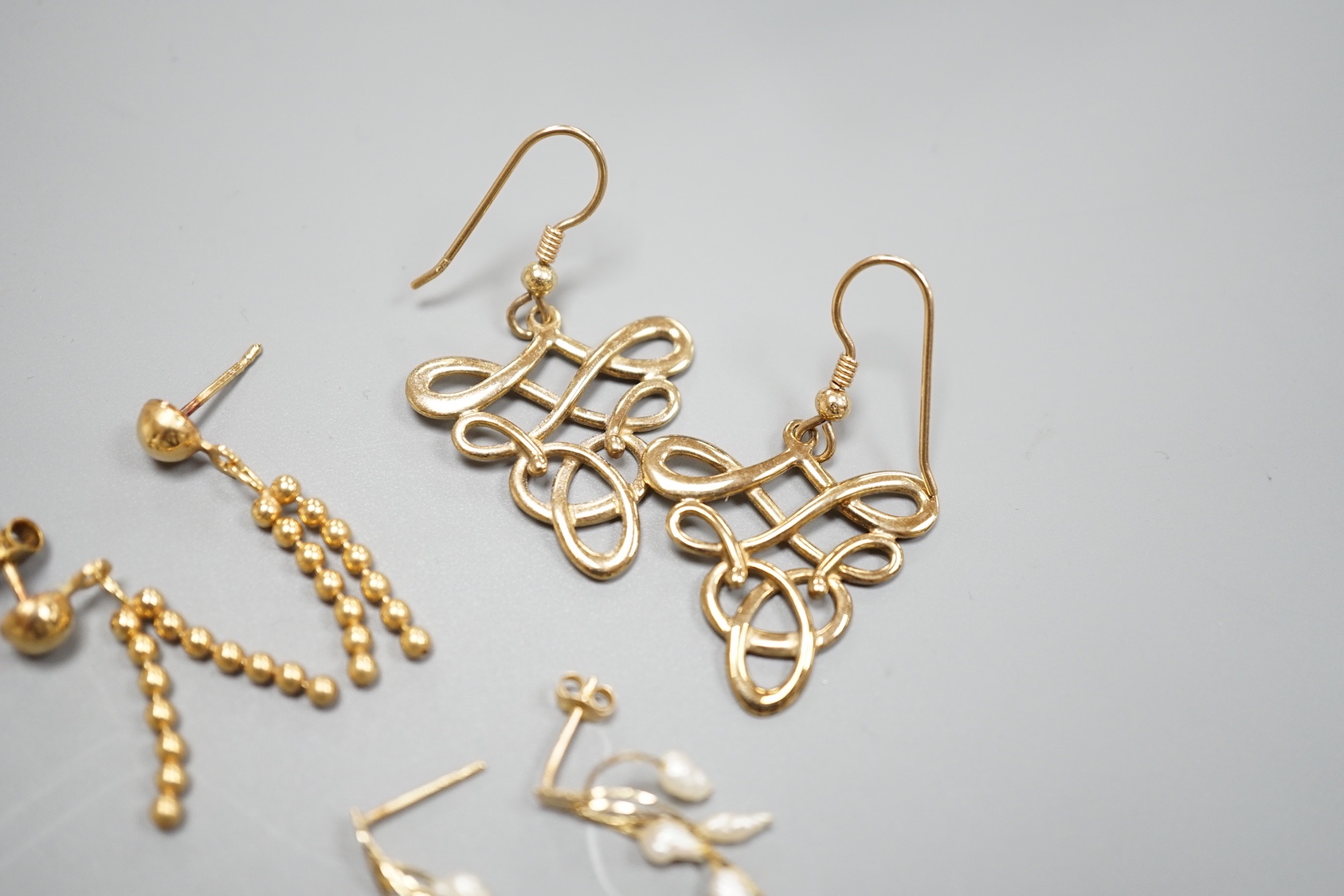 Two pairs of modern 9ct gold earrings including interwoven and tassel drop, 6.5 grams and a pair of 14k and baroque pearl drop earrings, gross 0.9 grams.